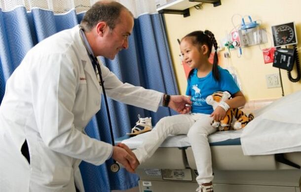 doktor kalça artrozu olan bir çocuğu muayene ediyor